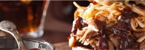 Close-up of tender pulled pork, showing the juicy, shredded meat with a rich, smoky texture and savory glaze.